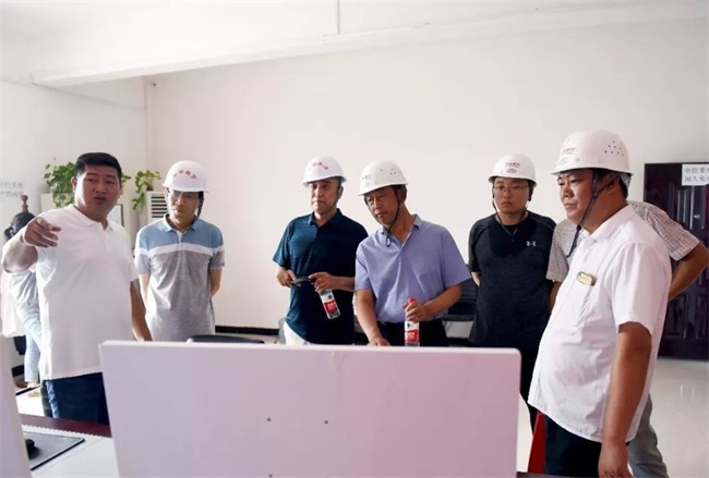團隊考察生產(chǎn)線上的中控室